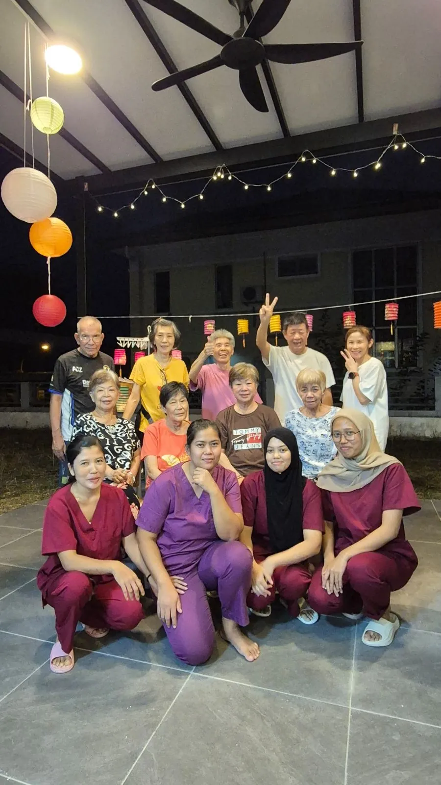 Residents and caretakers gathered under paper lanterns at night